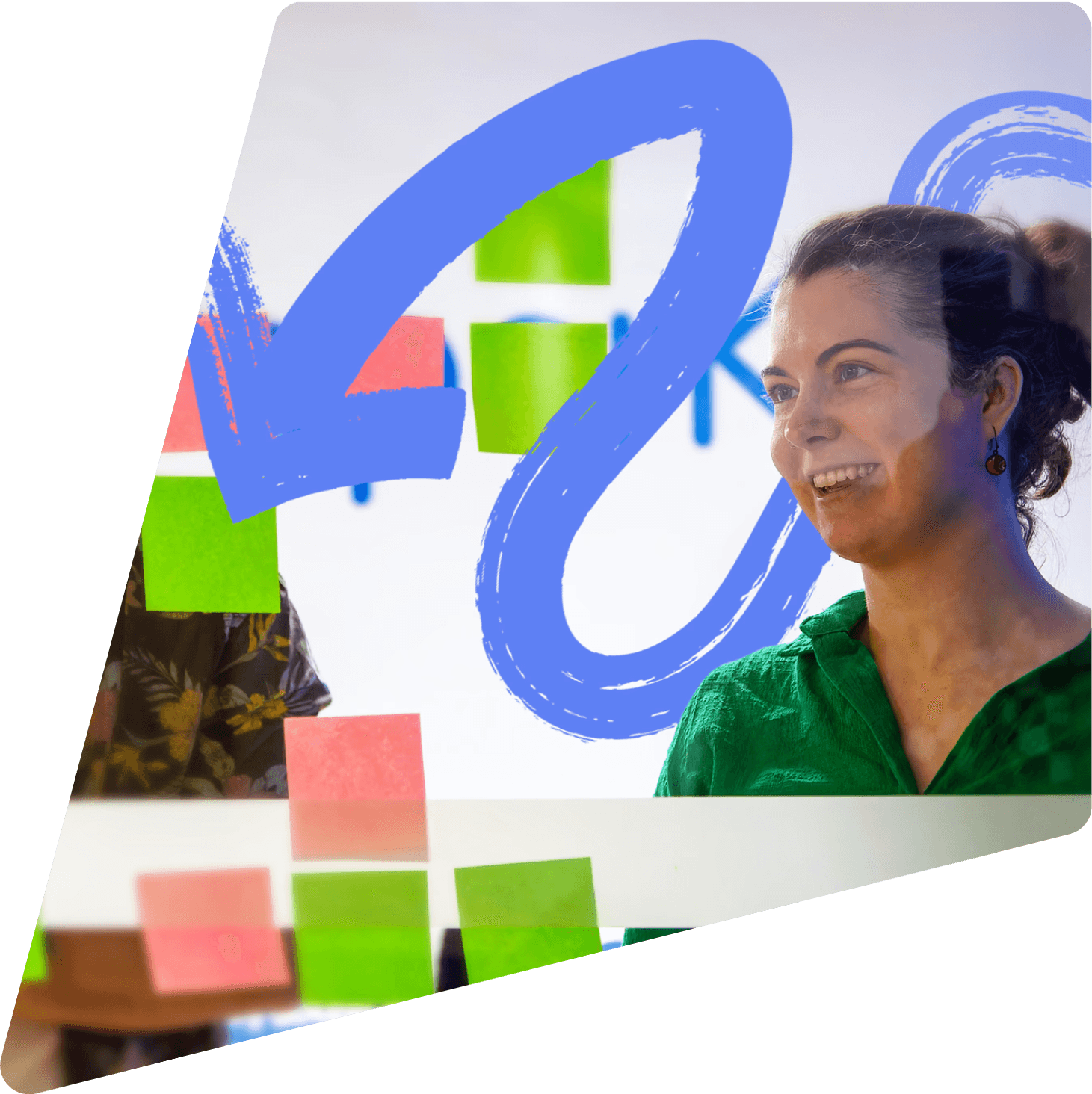 A PaperKite team member smiling beside a wall of sticky notes during a strategy workshop.